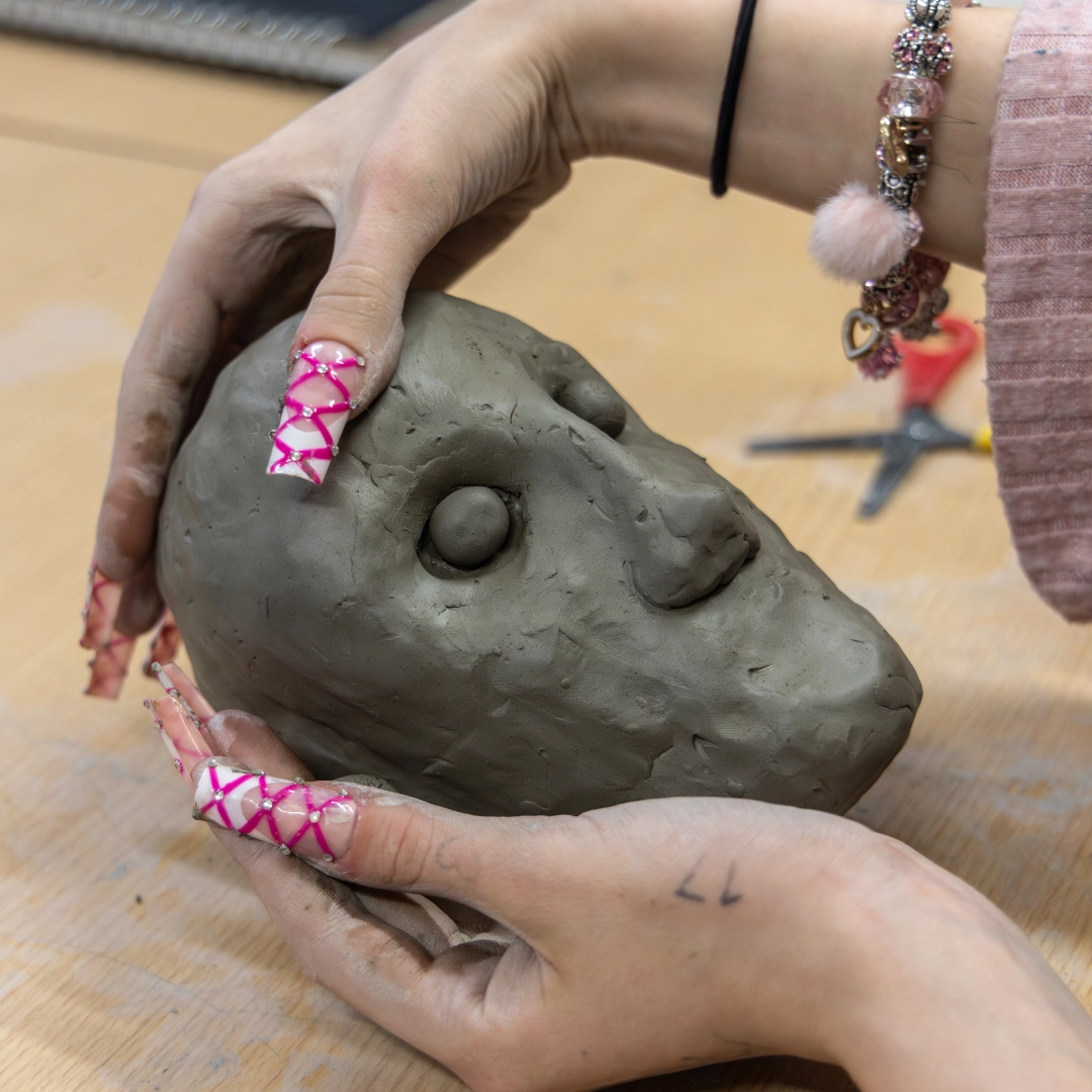 Art student smiling at the camera in a graphic design workshop