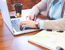 A person types on a laptop