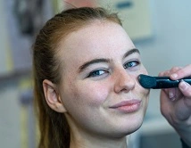 Beauty student having make up applied to her face