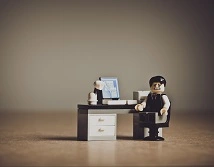 A Lego character at a desk